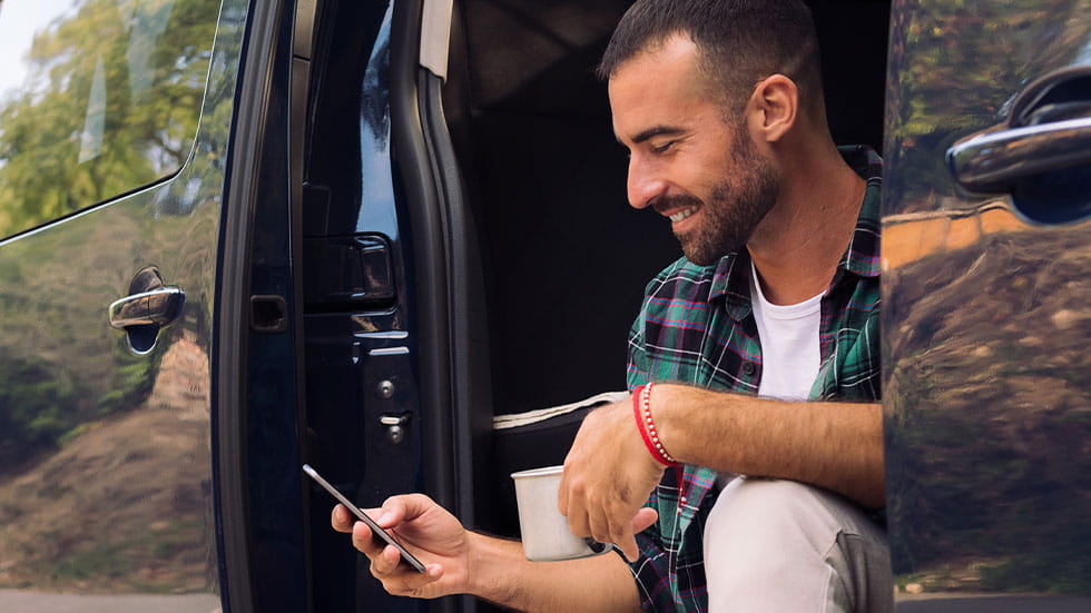 Man smiling at smartphone while sitting in RV