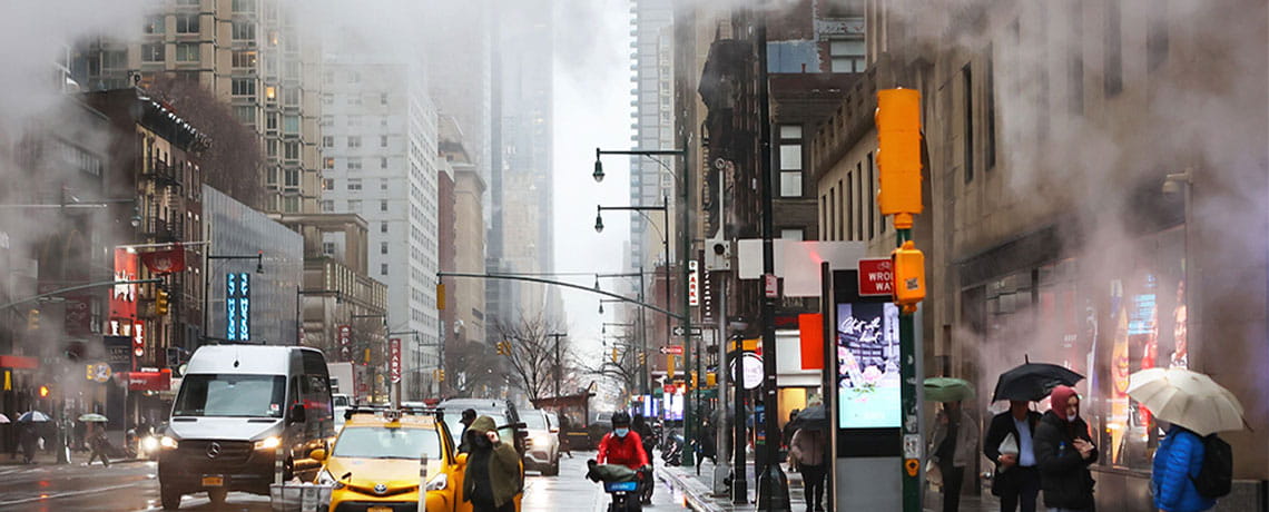Pedestrians and motorists navigate through a foggy, wintry day in New York City.