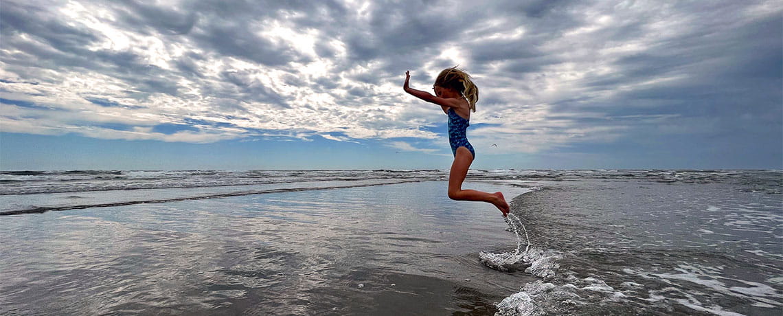 Little girl jumping at Jersey Shore in Ocean City, NJ.