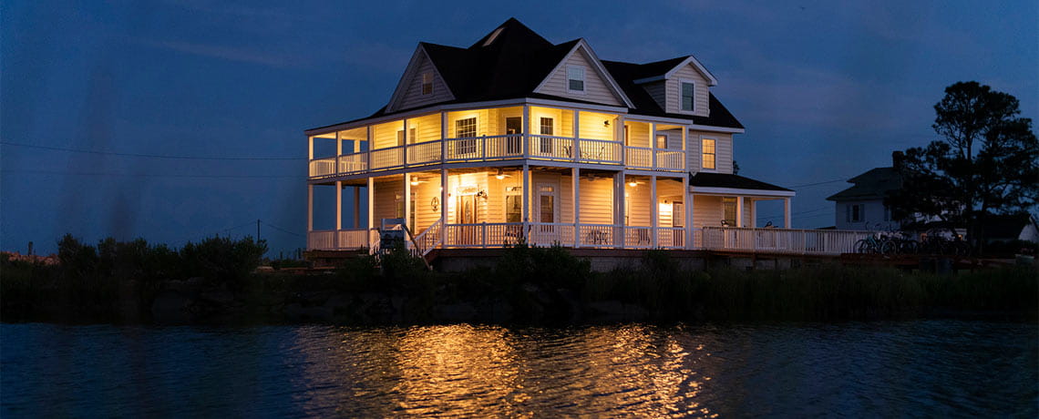A home lite up in the dark, reflecting on the Chesapeake Bay