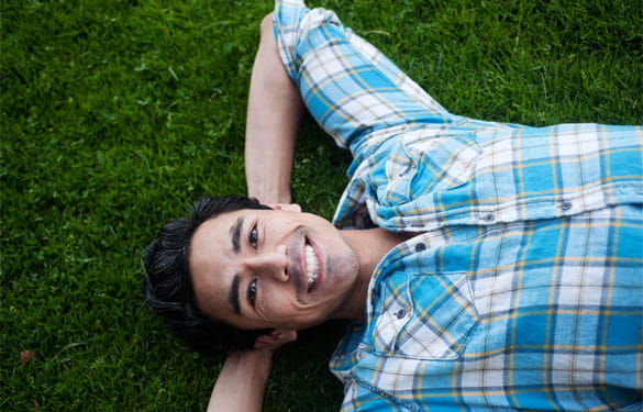 Guy smiling while laying in the grass