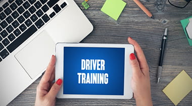 Woman's hands holding a tablet that reads "driver training"