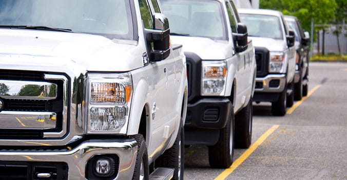 front side view of white trucks lined up in a row