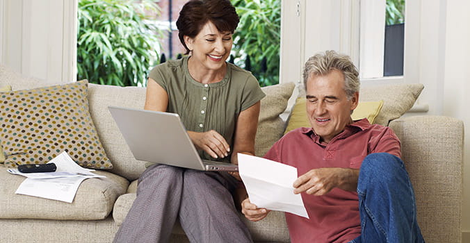 older couple reviewing bills and smiling