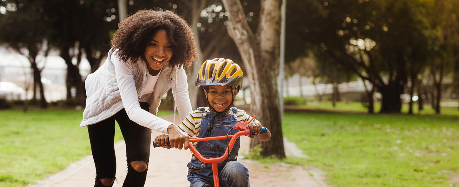 Mother teaching her child how to ride a bike
