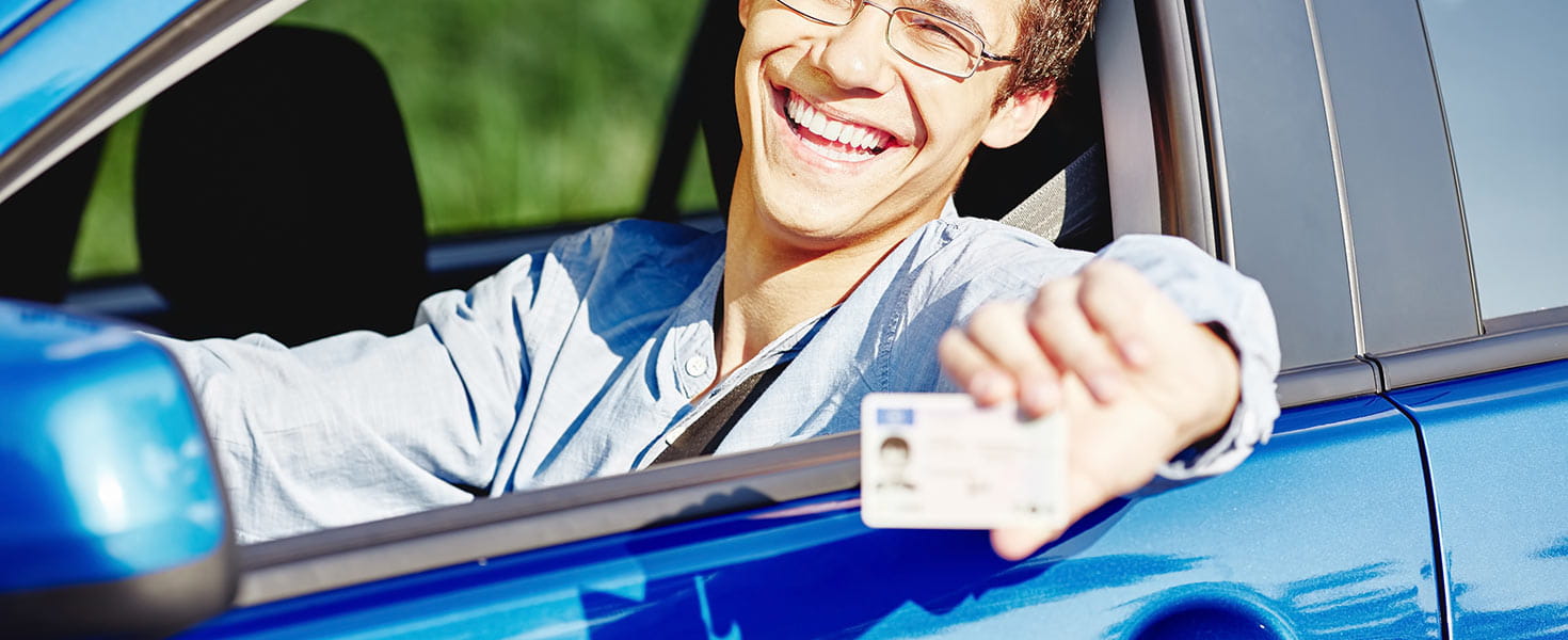 Teen driver holding his drivers license