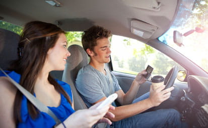 Teens Driver and Friend Distracted by Looking at Cellphones on The Road
