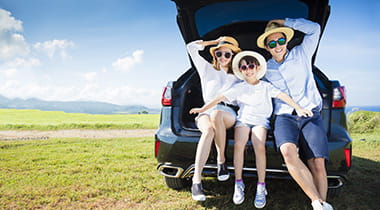 family in back of car going on vacation