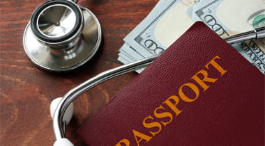 Stethoscope, passport and money laying on a table