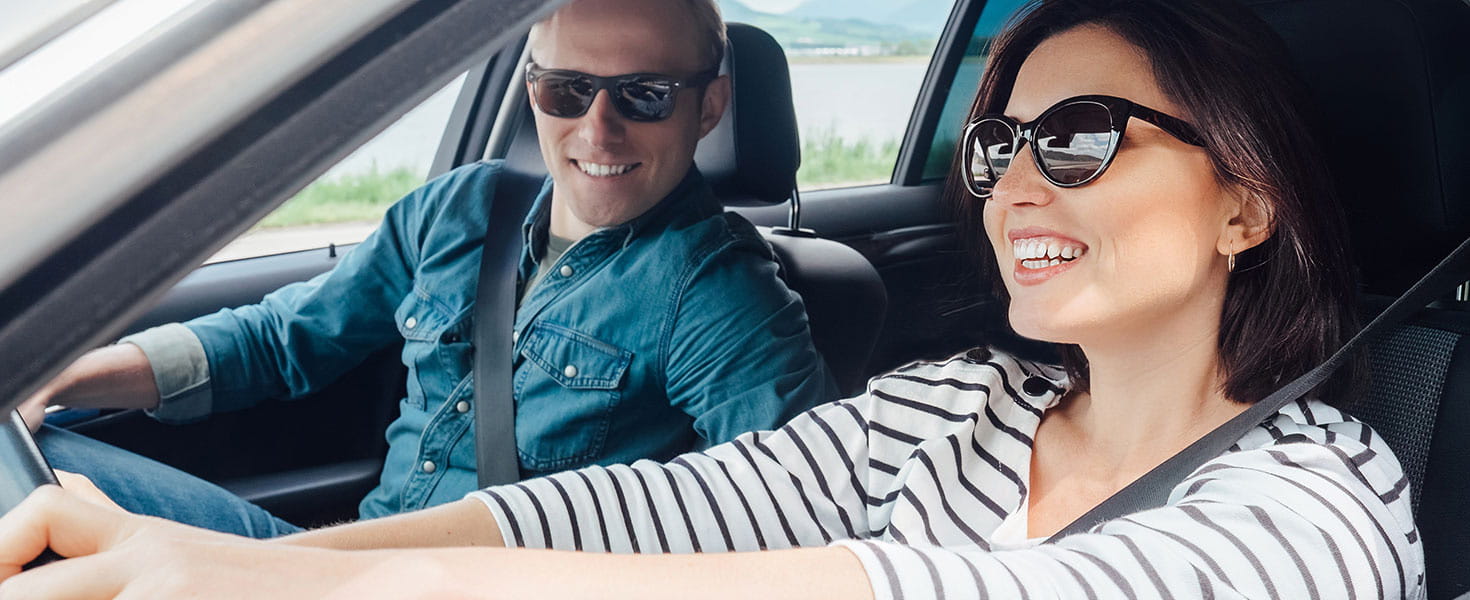 man-in-car-smiling-with-woman-in-car-smiling-while-driving