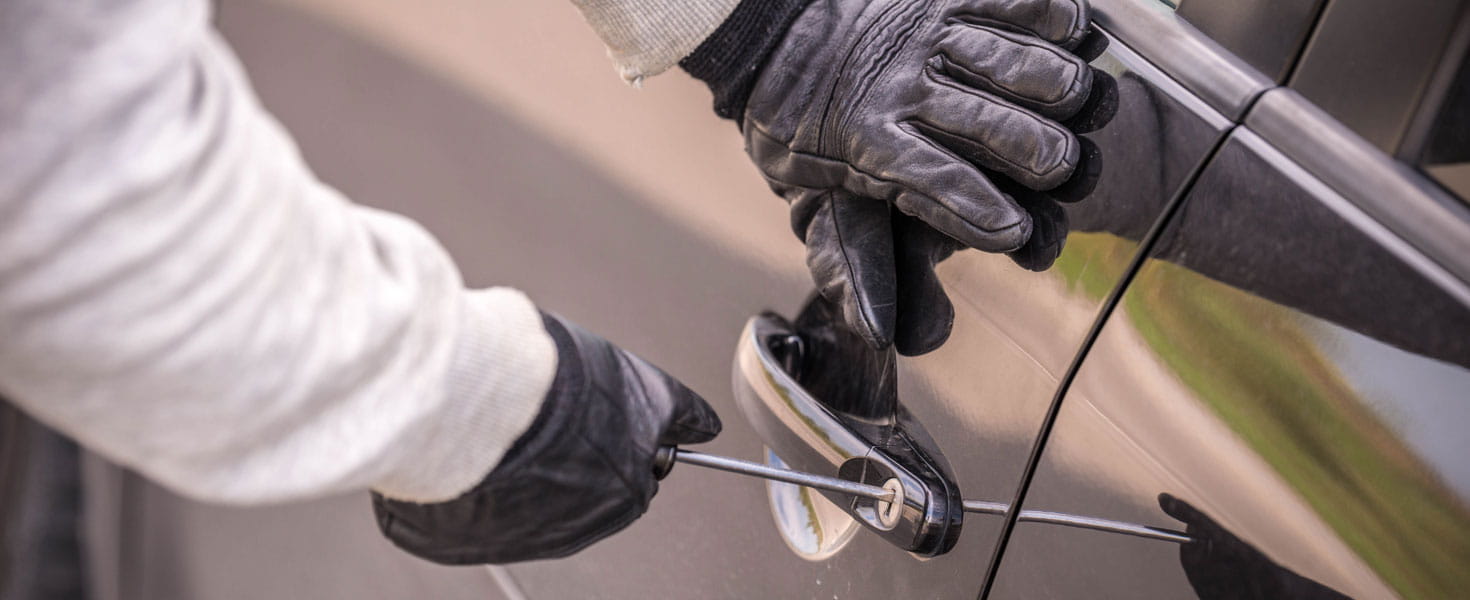 Hands in Gloves Using Screwdriver to Break into Vehicle