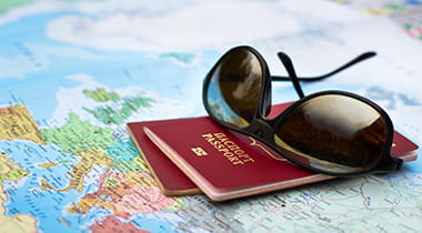 A pair of sunglasses sitting on passports and a map