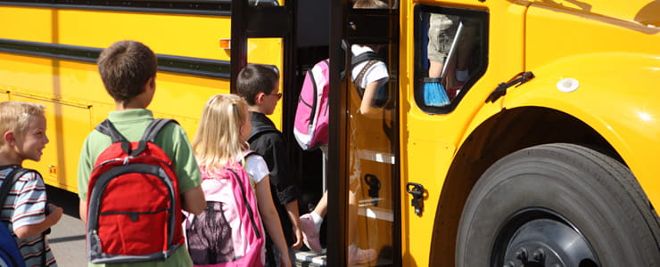 children getting on a school bus
