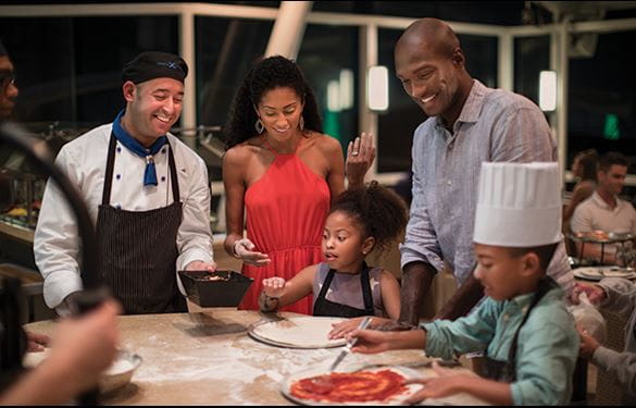 Family of four at a cooking class on a cruise ship, making pizza