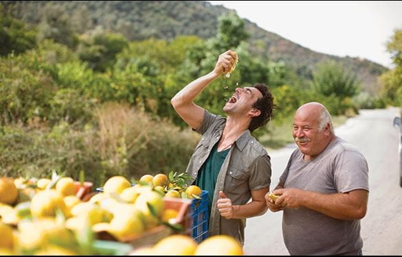 A man enjoying a fresh lemon squeeze, along with a friend