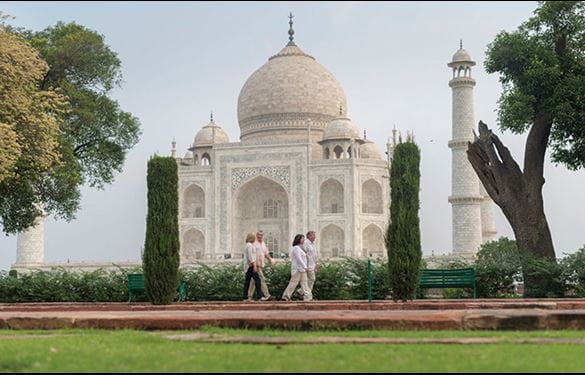 Tourists walk in front of Taj Mahal