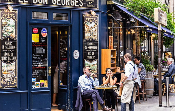 The charming Cafe Le Bon Georges. Parisians and tourists enjoy food and drinks at the street french cafe.
