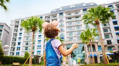 Little girl in front of Disney World hotel.