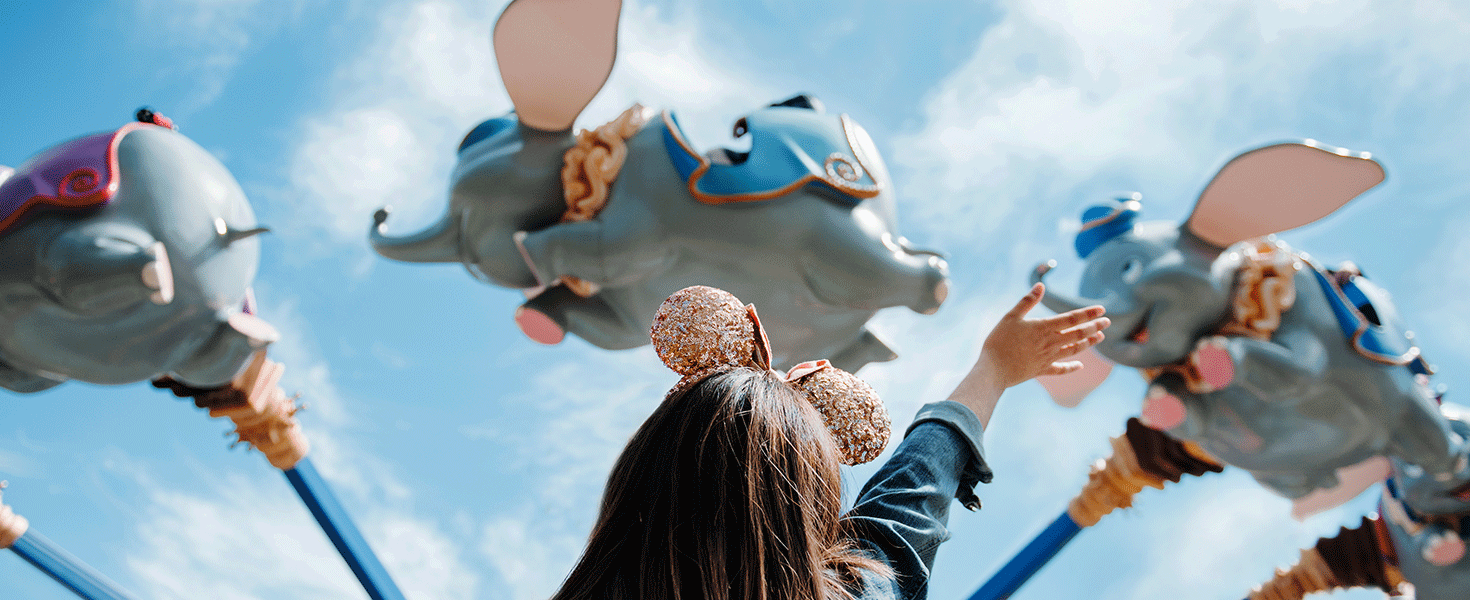Girl waving at guests on Dumbo Ride