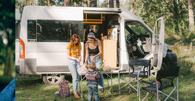 Family fixes a meal outside of their RV while on vacation
