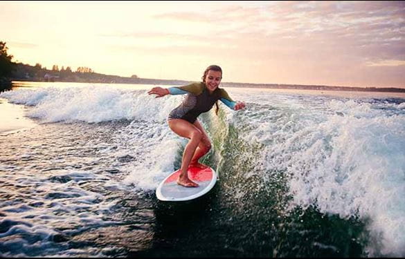 Young woman surfboarding at summer resort