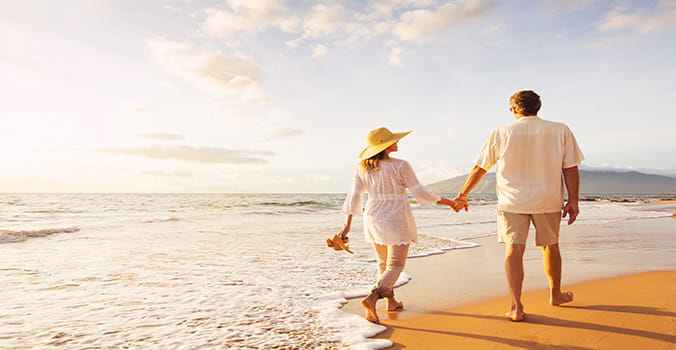 Man and Woman walking along beach in Hawaii holding hands