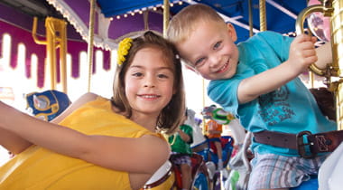 Kids on a Carousel in Amusement Park
