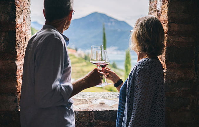 Couple overlooking scenery, toasting with a glass of wine