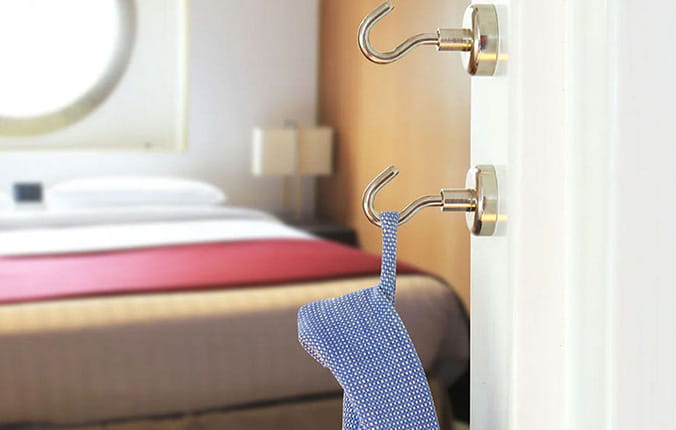 Magnetic clothing hooks in a cruise cabin, with a shirt hanging on one of the hooks