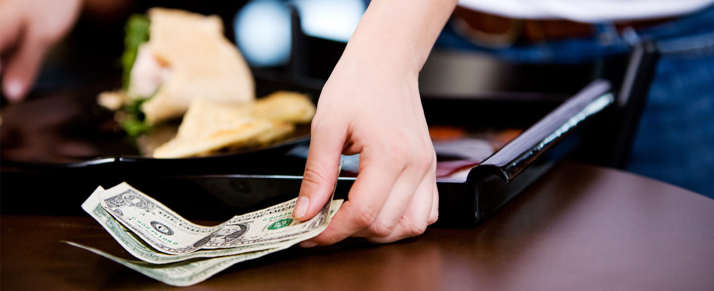 Lady leaving money on table in restaurant
