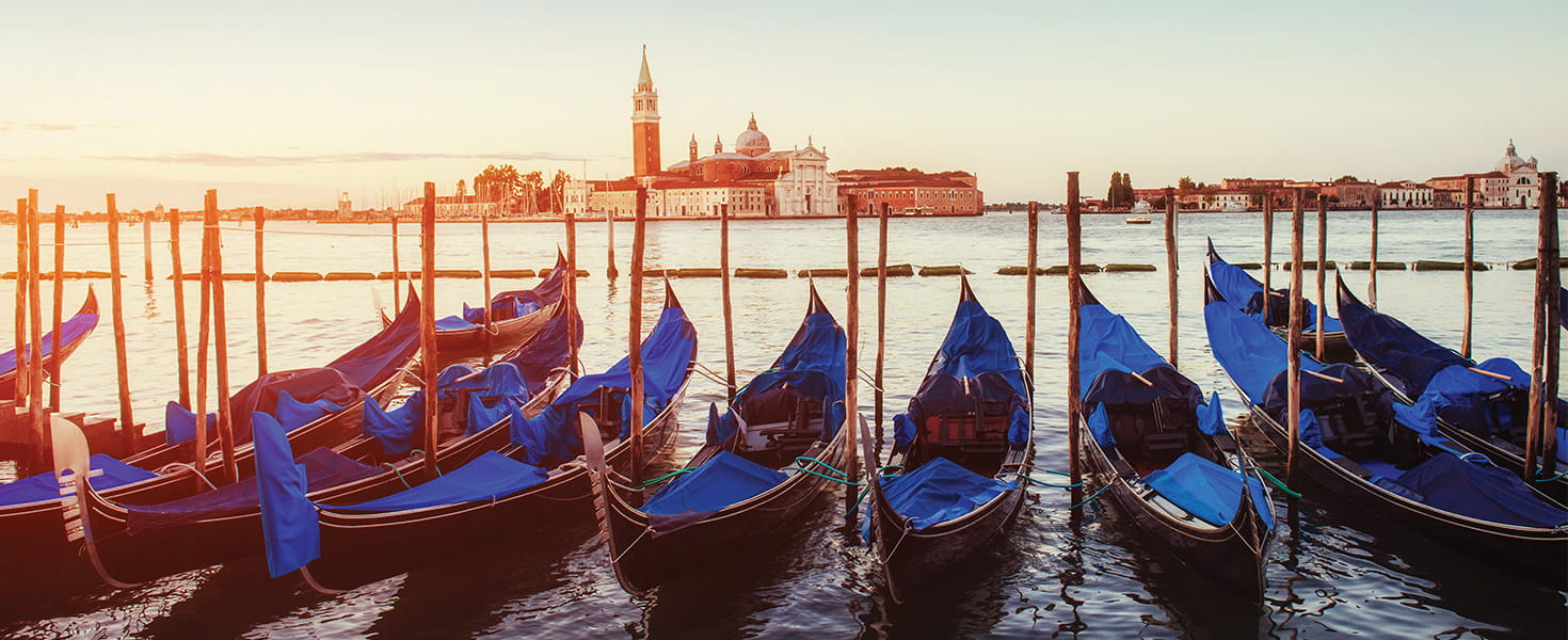 Gondolas on the water in the city of Venice at sunset