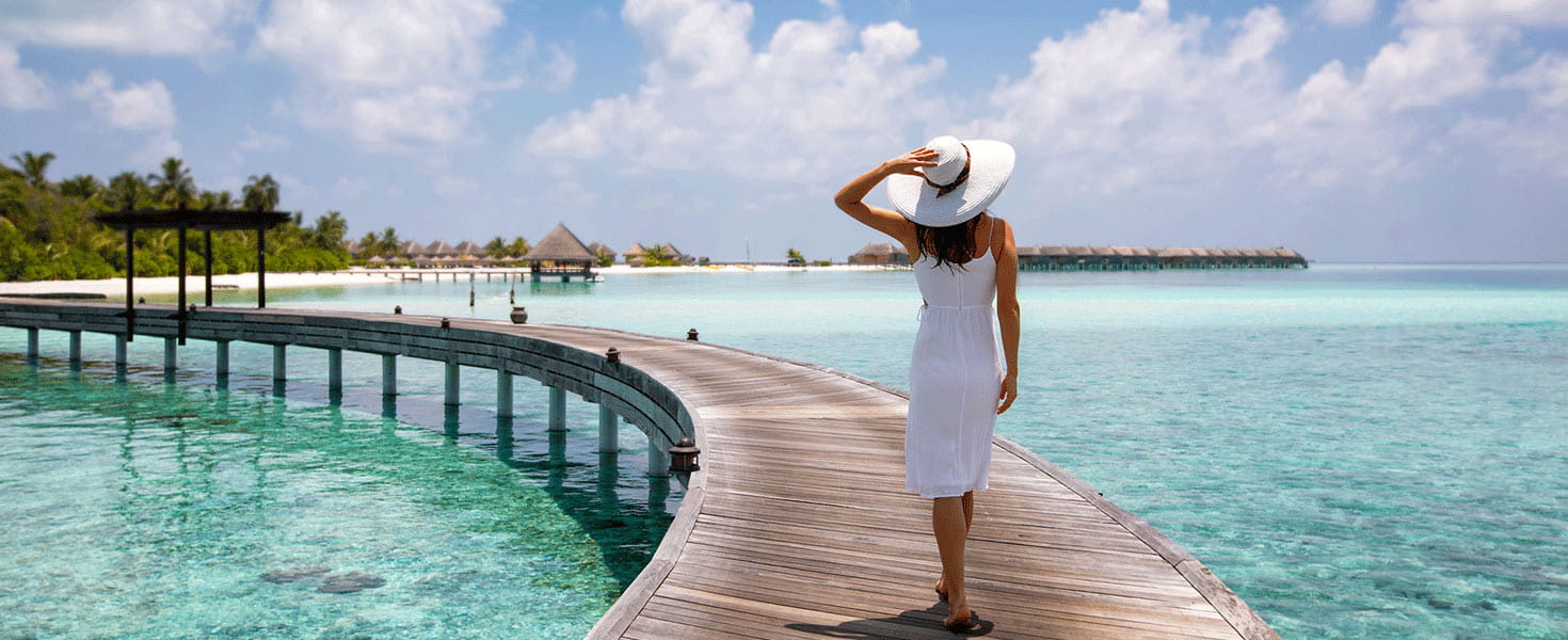Lady walking on pier in Maldives