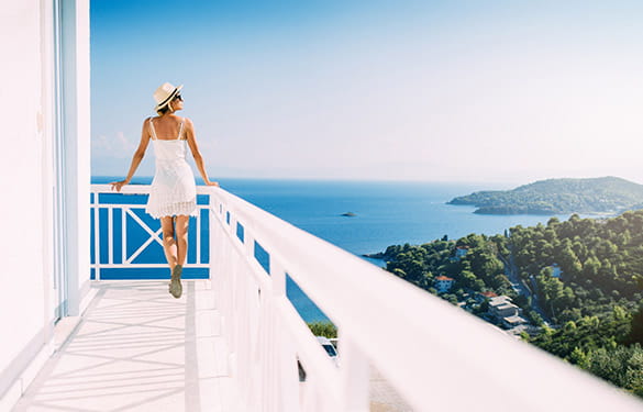 Woman on balcony overlooking the Mediterranean Sea
