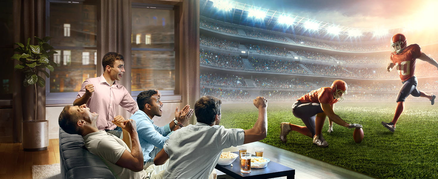 Friends enjoying football game at home, concept image with screen filling wall