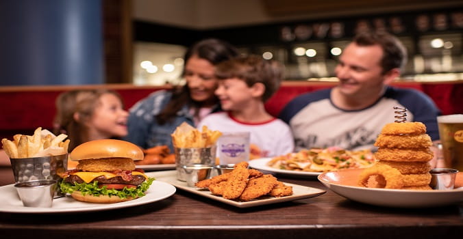 Family of four dining at Hard Rock Cafe with food in front of them