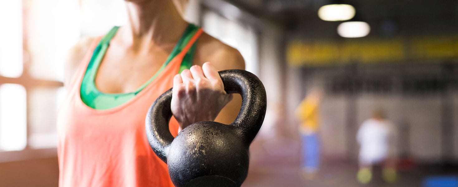 Active Fit Direct woman holding kettle bell in gym