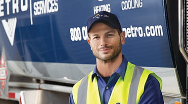 Petro Home Services heating oil delivery associate stands in front of delivery truck