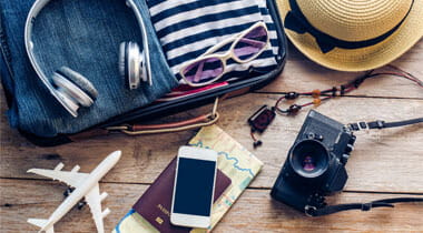 Clothes, Passport, wallet, glasses, smart phone devices, on a wooden floor in the luggage ready to travel