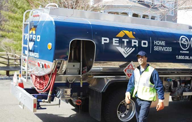 Petro Home Services worker standing in front of service vehicle.