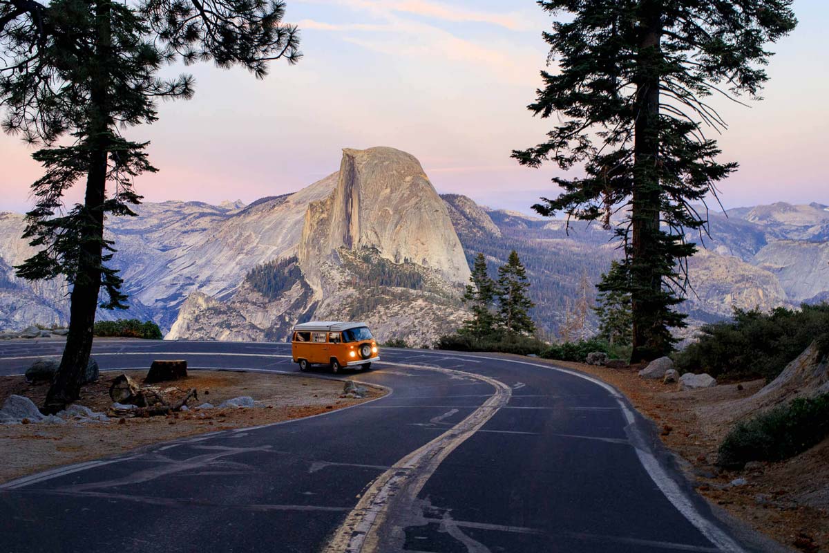 A Volkswagen bus driving up a windy road in Yosemite