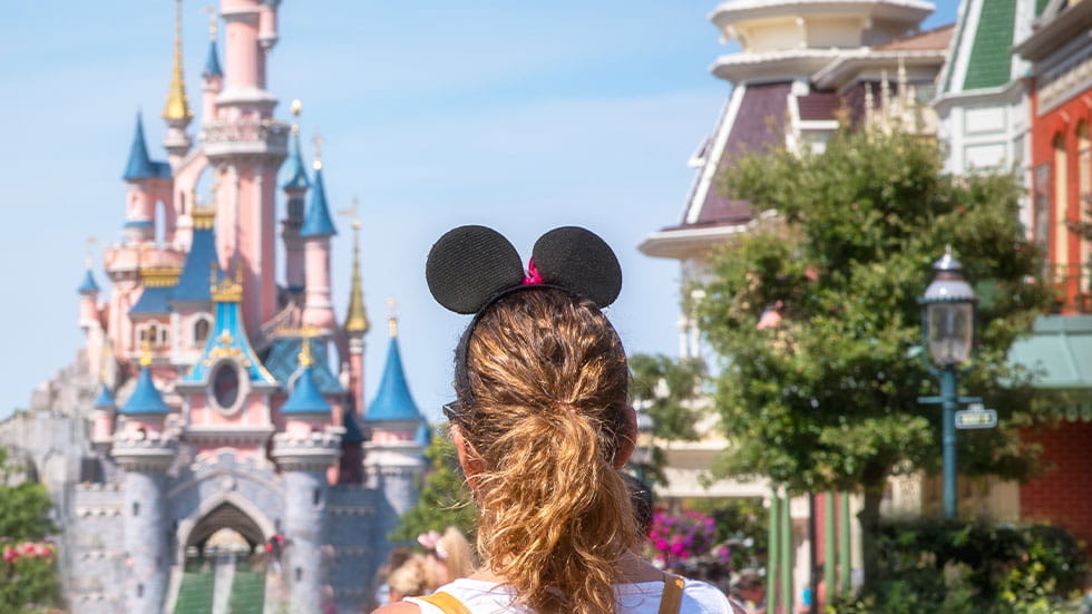 Woman wearing Mickey Mouse ears, photo taken from behind