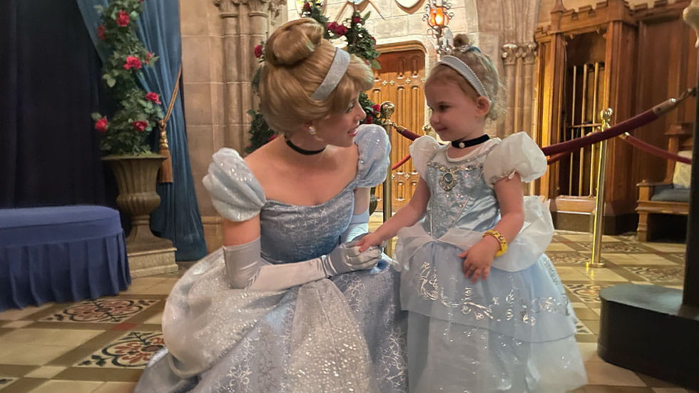 Little girl in Cinderella costume having picture taken with Cinderella at Disney World