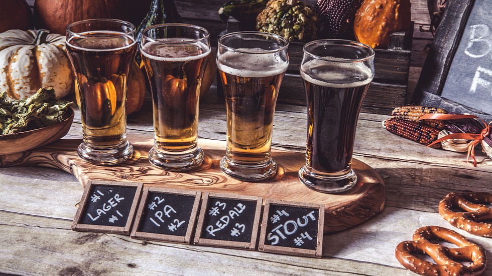 variety of beer placed on a table with fall decorations 