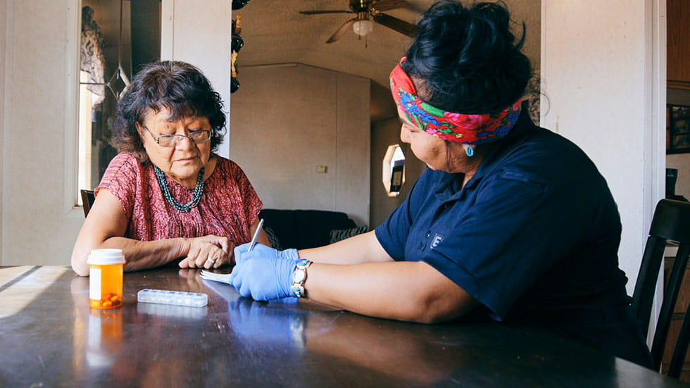 Nurse and older woman going over medical information