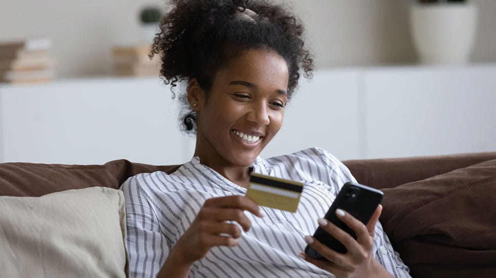 Girl using phone, holding credit card