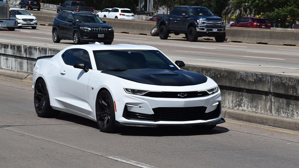 White and black Chevy Camero driving on highway