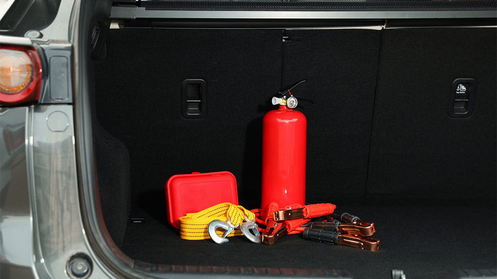 fire extinguisher, cables, jumper cables and first aid kit in back of car