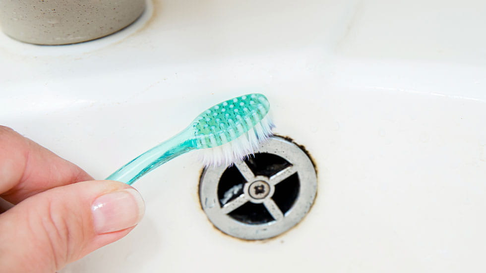Cleaning sink with toothbrush