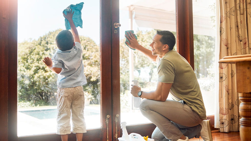 father cleaning windows with son