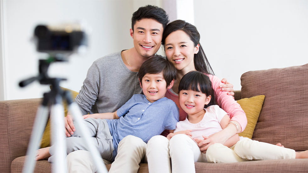 family posing for a photo with a camera tripod setup